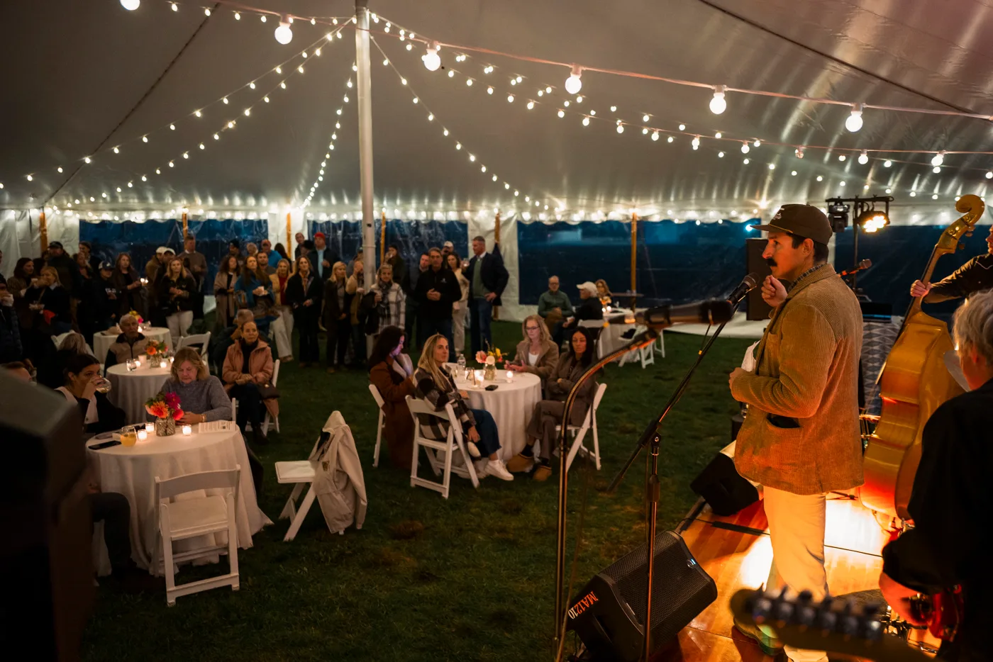 Musician performing for guests beneath a lighted event tent at Fort Adams