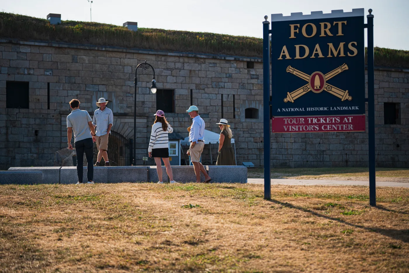 Visitors approaching the entrance beside the Fort Adams sign