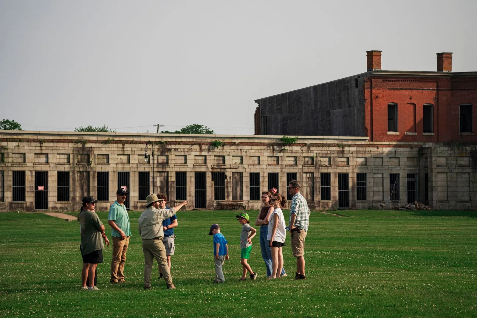 A Fort Adams guide leading a family tour across the parade field in front of the casemates